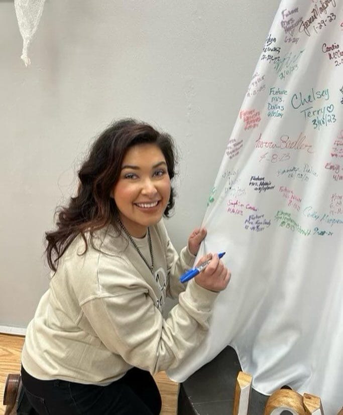 Bride signing wedding dress at AJ Bridal Company