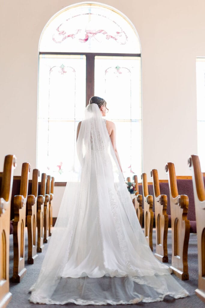 Bride walking down aisle in wedding dress.