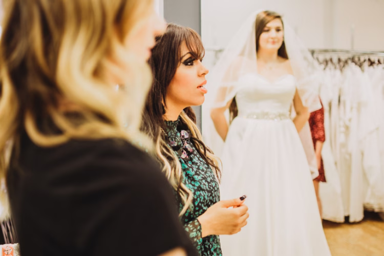 Bridal consultant helping a bride adjust the fit of her wedding gown