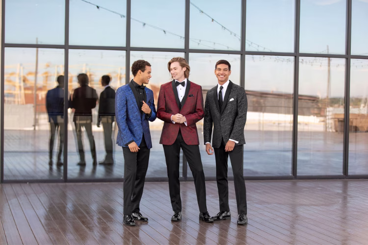 Three men wearing colorful tuxedo jackets at a formal event